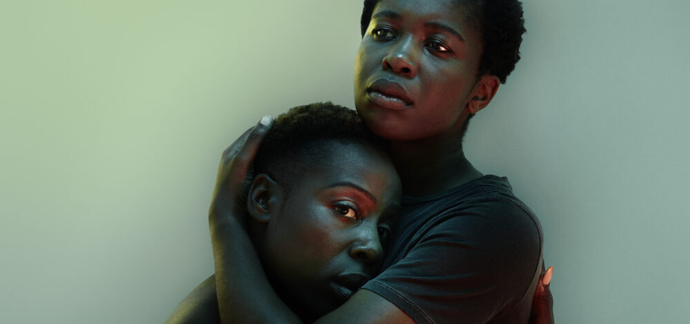 A photo of two people embracing. They look worried.