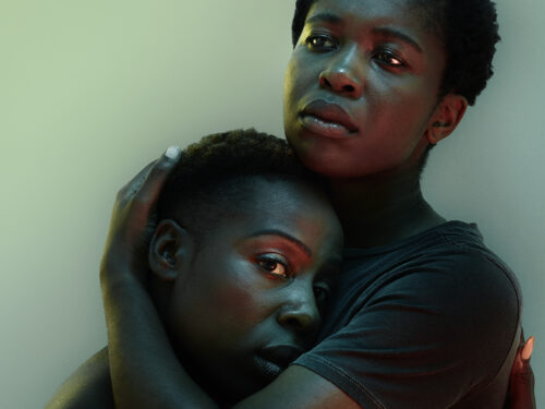 A photo of two people embracing. They look worried.