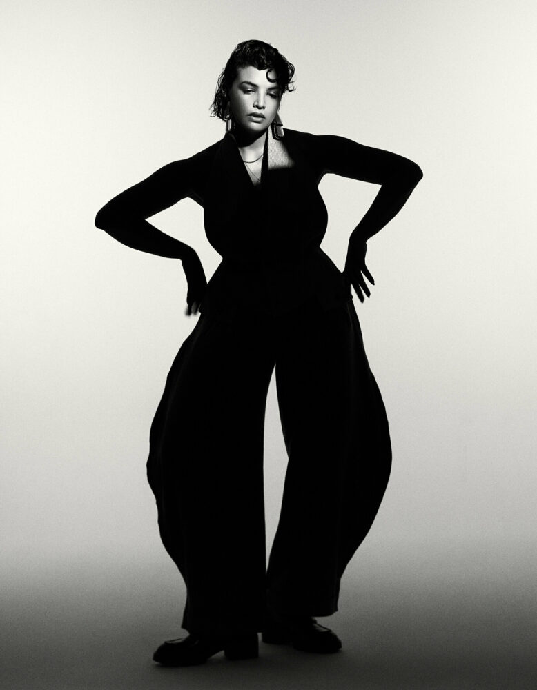 Black and white image of a woman wearing a black trouser suit