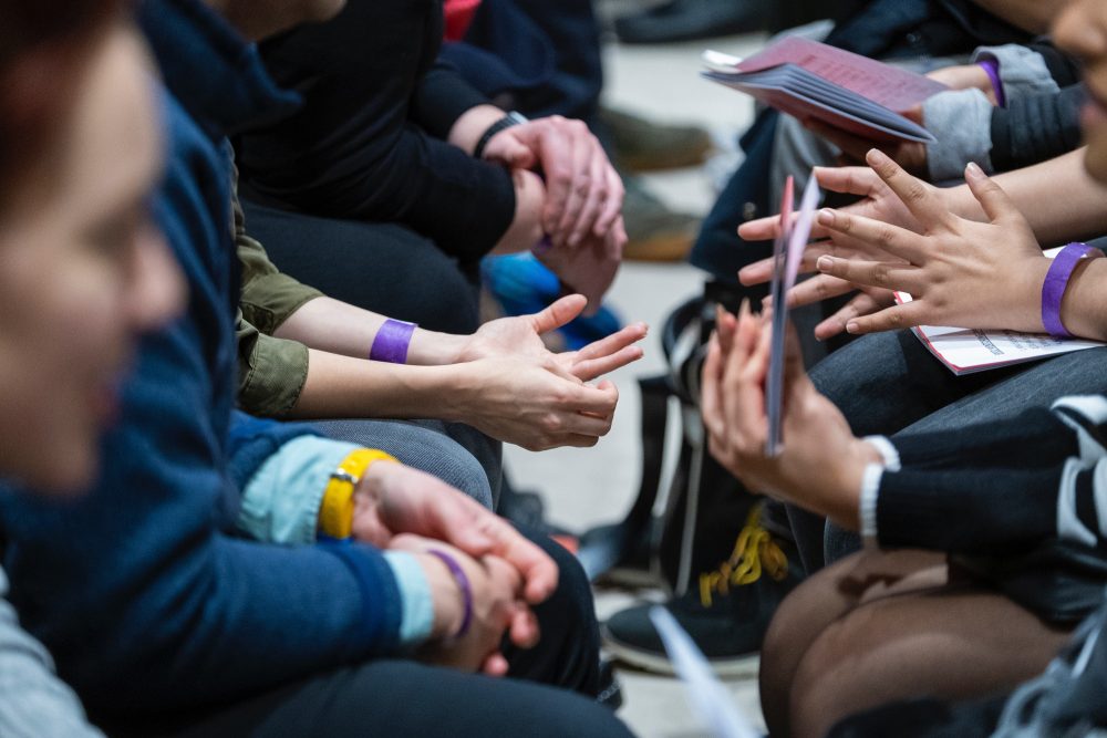 Close up of volunteer and young people’s hands at an introduction event