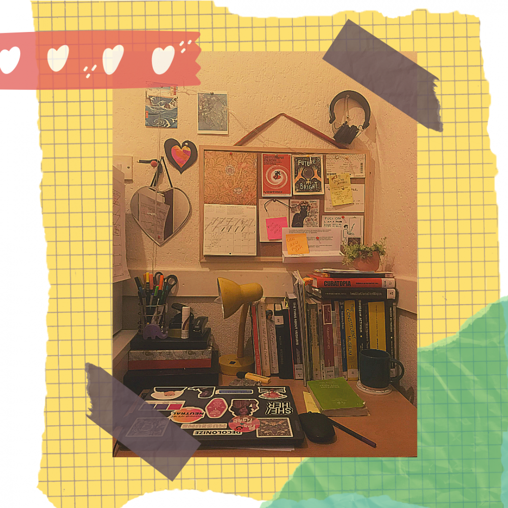 A photo of a desk space with laptop, noticeboard, folders and a lamp. The image is collaged on top of graph paper and