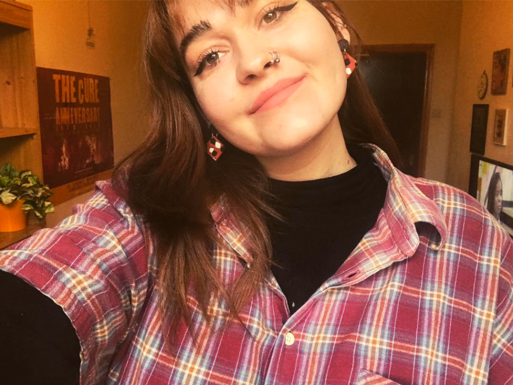 Head and shoulders view of a young woman wearing a check shirt