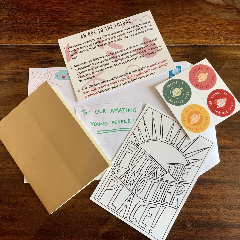 A selection of postcards, stickers and notebook on a wooden surface. An envelope reads to our amazing young people.