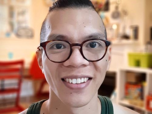 A head and shoulders view of Michael Poon smiling and wearing glasses