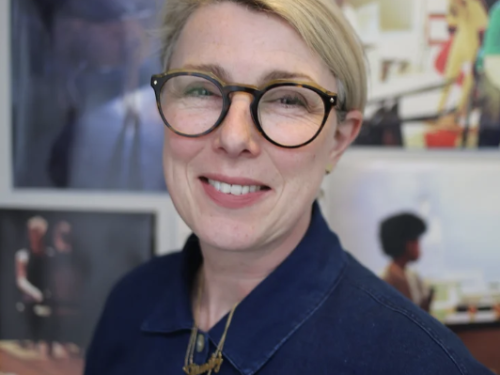 A female person wearing glasses with short blonde hair smiling