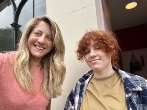 2 people, one 17 years old with red hair and someone in their 30s with blonde hair. They are smiling.