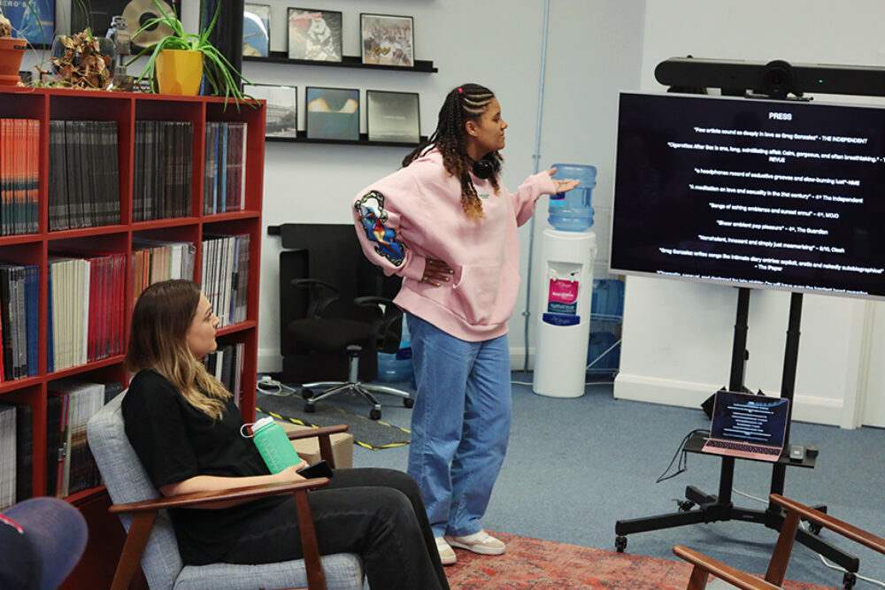 A person aged 17 wearing a pink jumper and blue jeans presented to a person.